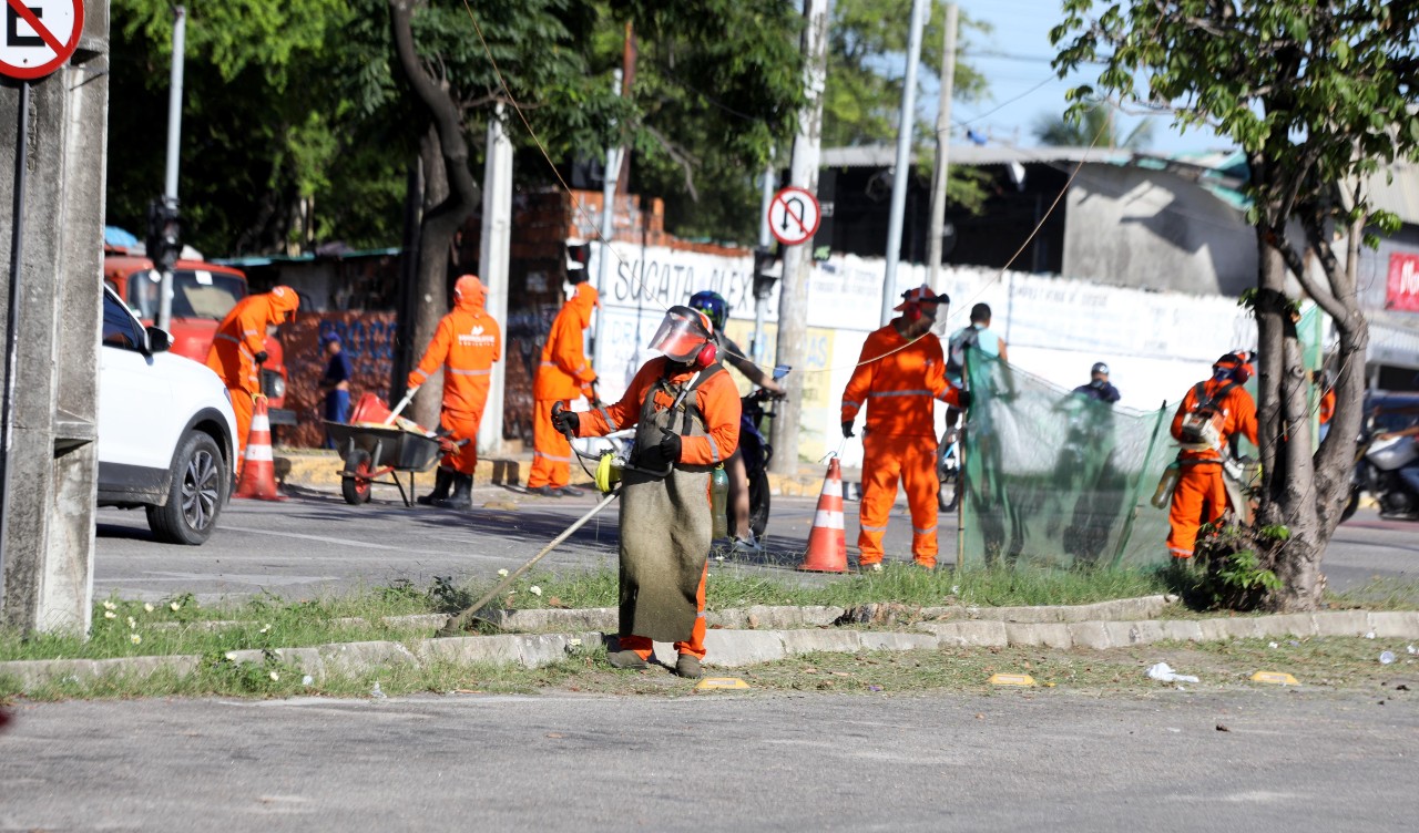 homens trabalhando no serviço de varrição de uma avenida